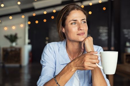 Woman thinking and drinking coffee